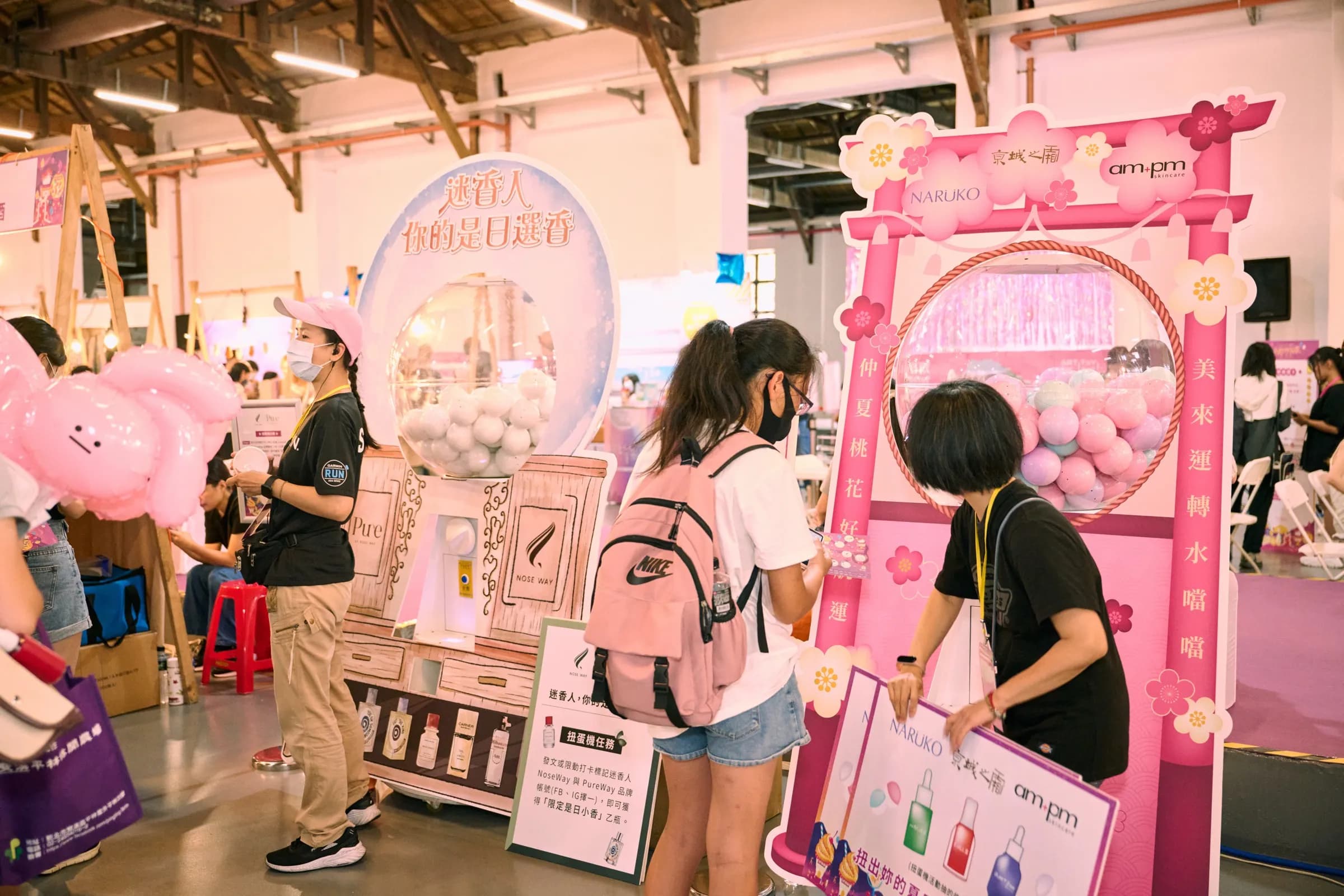 2023 女生日常節的粉色品牌攤位，參加者在攤位前參觀體驗